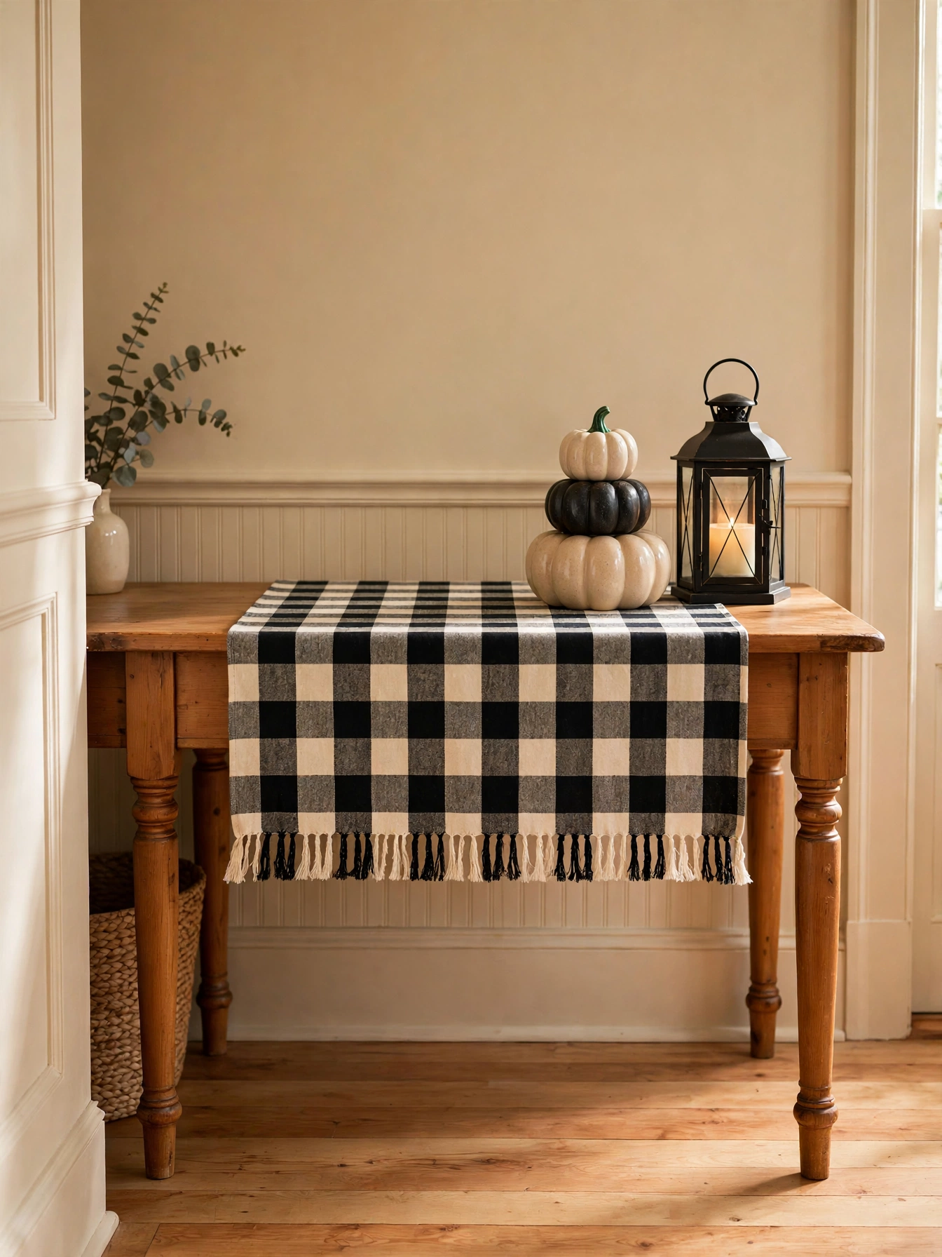 Fall entry table decor ideas for autumn 2026: a buffalo check plaid runner layered on a farmhouse console under small pumpkins and a lantern.